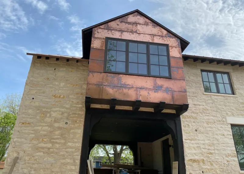Copper metal panel facade on a stone building for Roof Repair in Keystone